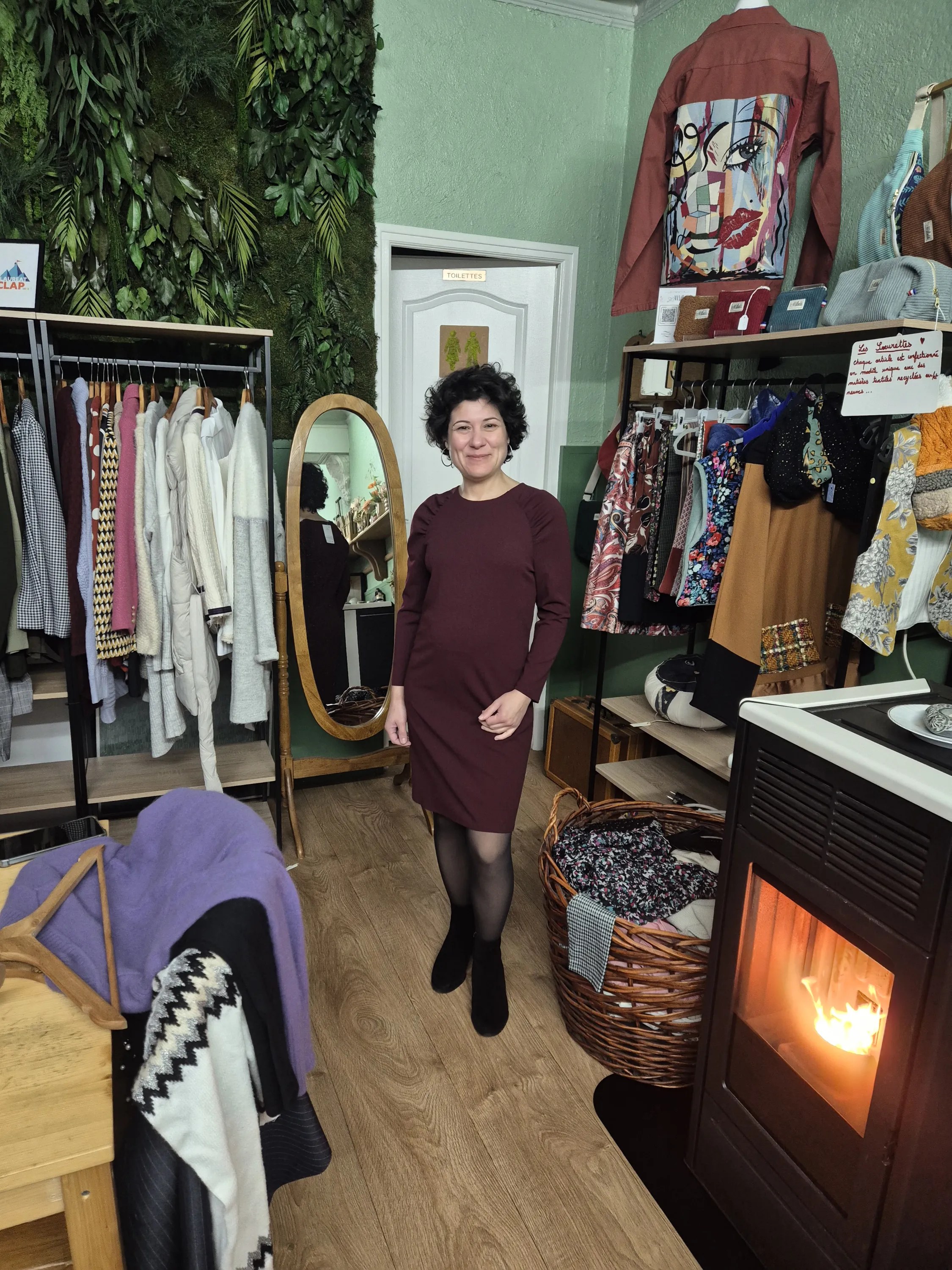 Sabrina en séance de shopping personnalisé, essayage d'une robe bordeaux devant un miroir en boutique
